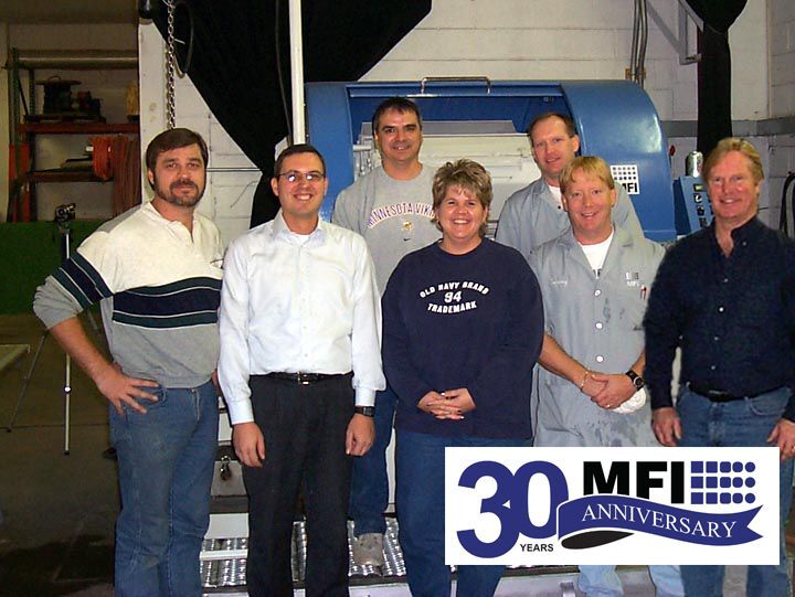 MFI employees and customer standing in front of an HZ-220 Centrifugal Barrel Finishing Machine.